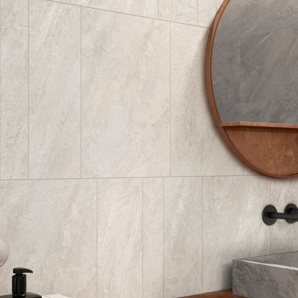 Baño revestido en Moon Beige con bacha de piedra y grifería negra