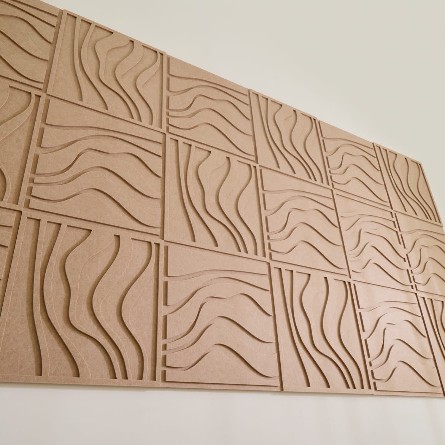 Detalle del panel acústico de cerca: el relieve del corte y la junta entre placas