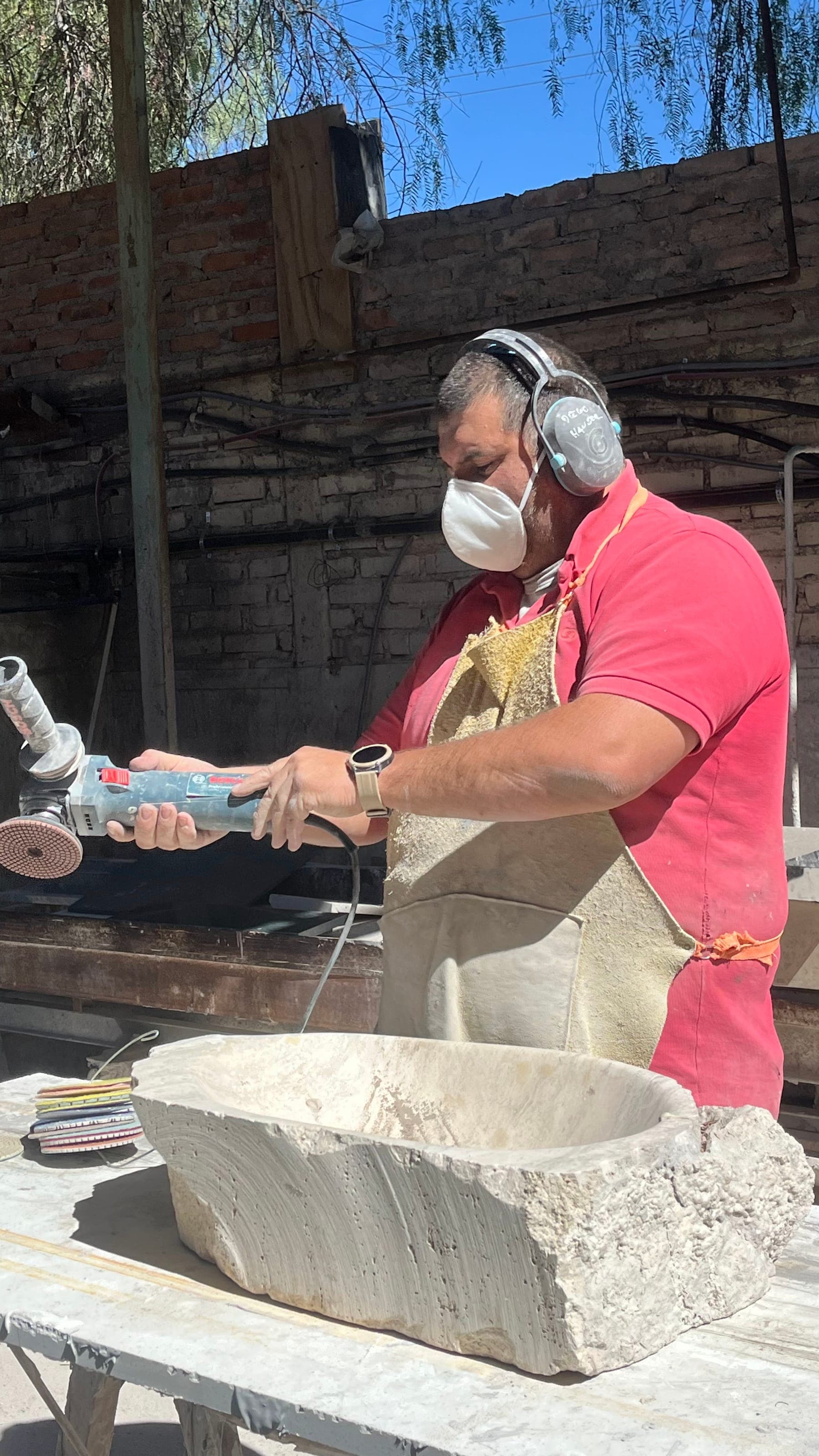 Operario terminando a mano una pieza de piedra en el taller de Puro Mármol