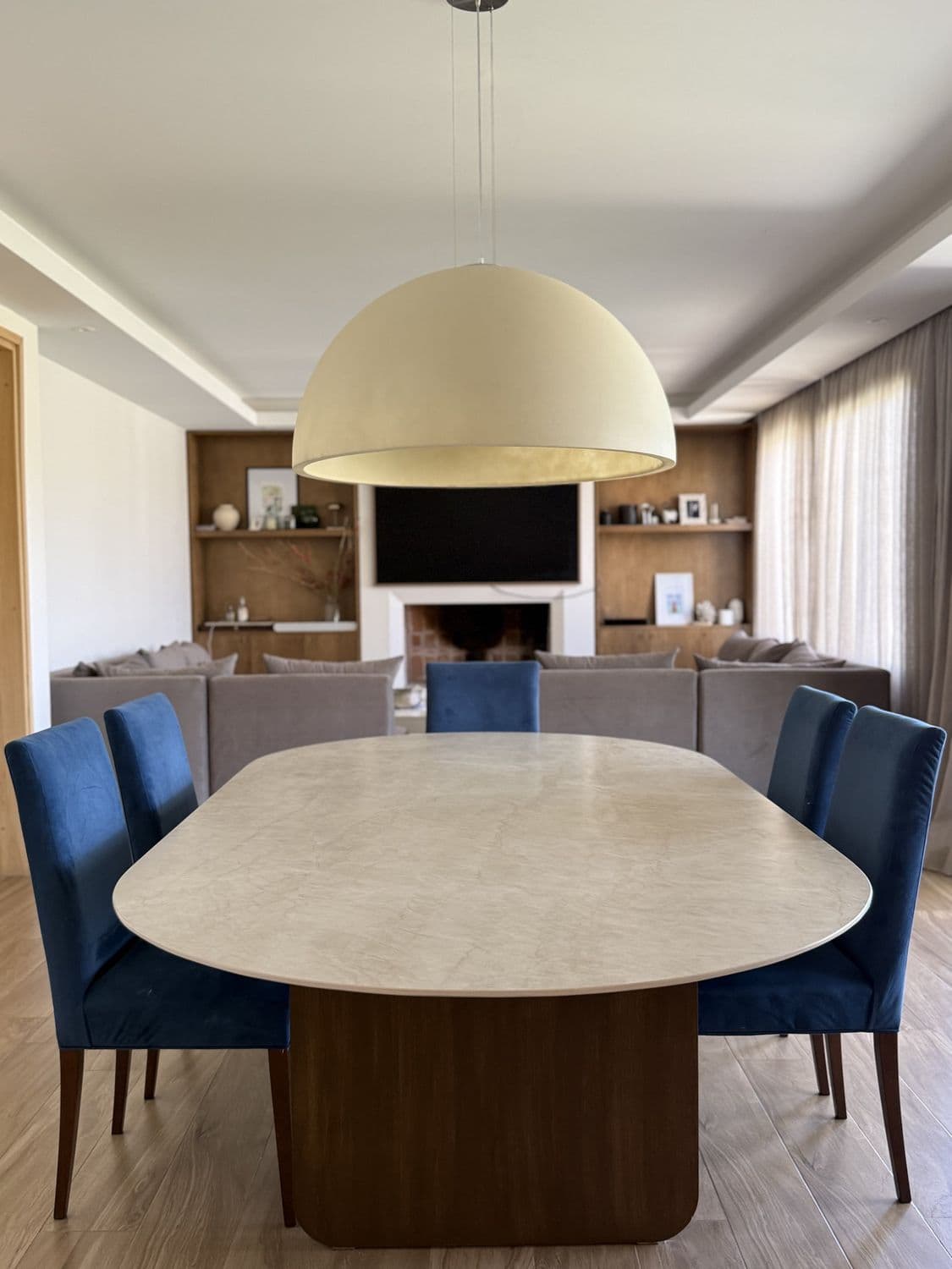 Mesa ovalada de piedra en el comedor, con la lámpara centrada encima