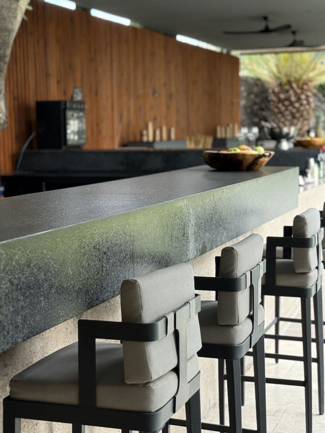 Barra exterior con banquetas de madera y mesada de piedra