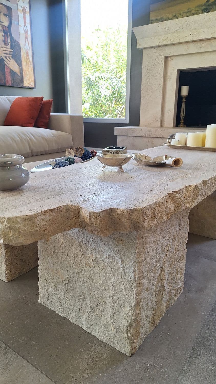 Mesa maciza de travertino con el canto natural sin pulir y patas de bloque