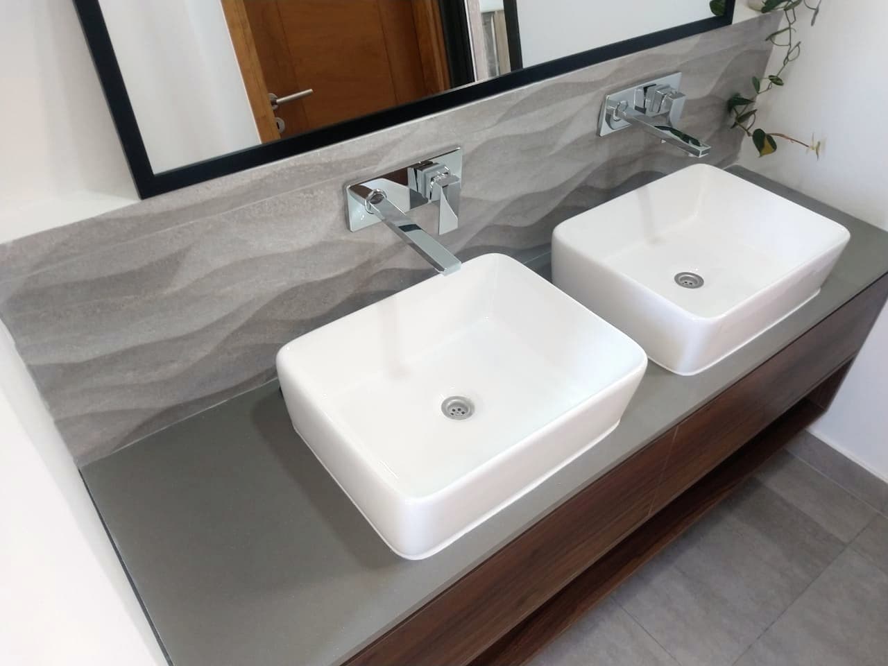Mesada de baño en cuarzo gris con dos bachas de apoyo