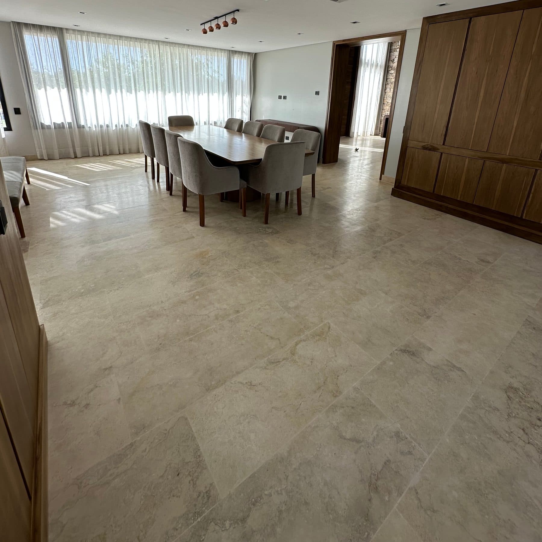 Living comedor con piso de travertino claro en placas grandes